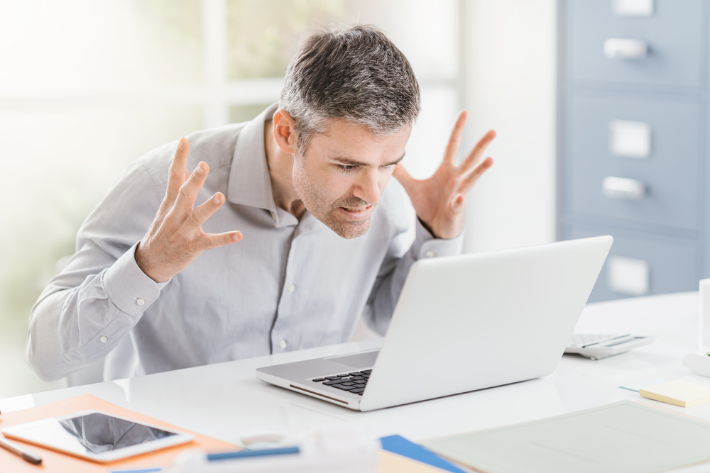 Homme agacé par son ordinateur